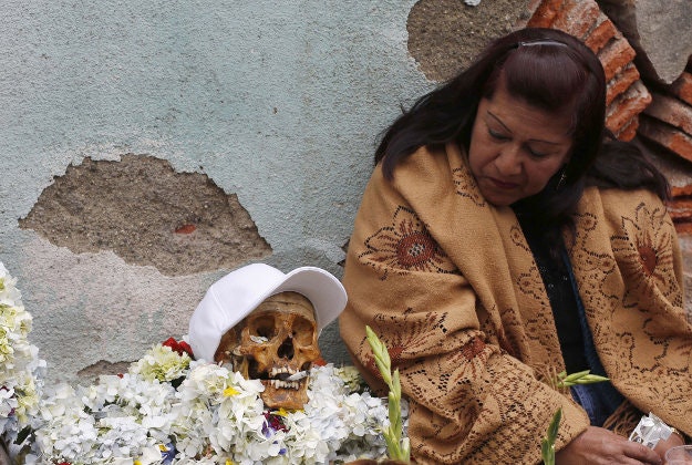 A woman looks at her decorated human skull or "natitas" as she waits to be greeted by the priest inside the Cementerio General chapel, during the Natitas Festival celebrations, in La Paz, Bolivia. 
