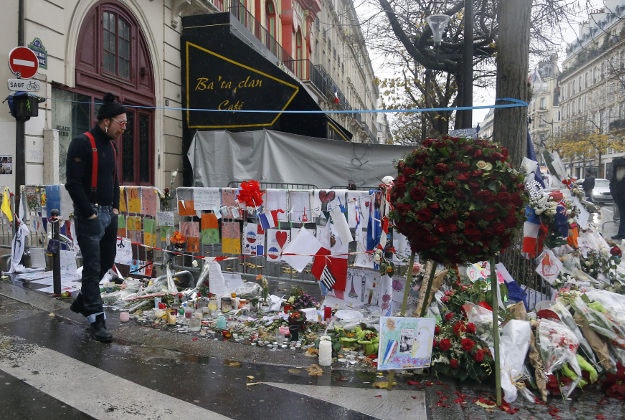 A member of the band Eagles of Death Metal, Jesse Hughes, pays his respects to 89 victims who died in a Nov. 13 attack, at the Bataclan concert hall in Paris, France, Tuesday, Dec. 8, 2015. Members of the California rock band Eagles of Death Metal are back at the ravaged Paris theater where they survived a massacre by Islamic extremist suicide bombers. 