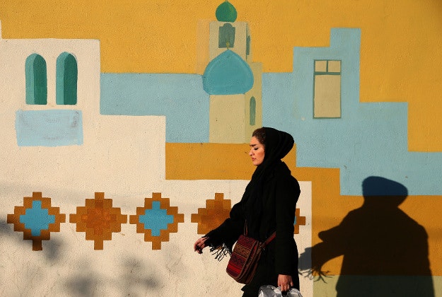 An Iranian woman walks on Enghelab-e-Eslami (Islamic Revolution) St. in Tehran, Iran, Tuesday, Dec. 8, 2015. 