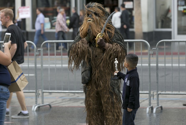 A boy gets his photo taken with Star Wars character Chewbacca outside the TCL Chinese Theater Imax as fans await the premiere of "Star Wars: The Force Awakens" in Los Angeles Wednesday, Dec. 9, 2015. 