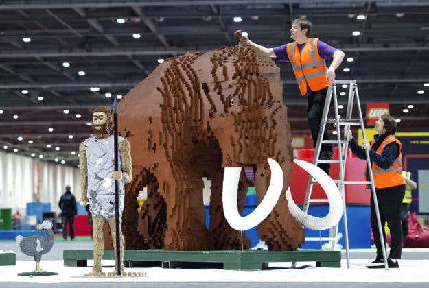 (from left) Co-director of Bright Bricks Ed Diment and Annie Diment apply the finishing touches to a female woolly mammoth made from approximately 400,000 bricks, ahead of the forthcoming Brick 2015 Lego show held at ExCel London from Friday December 11. 