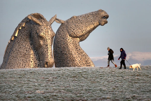 Dog walkers pass the Kelpies in early morning sunshine on the Forth and Clyde canal near Falkirk, following heavy overnight frost across Central Scotland. 