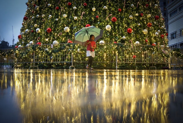 A young Malaysian girl walks in front of a Christmas tree at a mall in Kuala Lumpur, Malaysia, Sunday, Dec. 13, 2015. The spirit of Christmas is felt very much in Muslim-dominated Malaysia, as shopping malls in Malaysia have decorated their premises with Christmas trees, lights, Santa Claus and carols as a chance to boost year-end sales. 