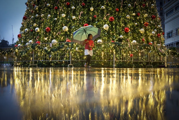 A young Malaysian girl walks in front of a Christmas tree at a mall in Kuala Lumpur, Malaysia, Sunday, Dec. 13, 2015. The spirit of Christmas is felt very much in Muslim-dominated Malaysia, as shopping malls in Malaysia have decorated their premises with Christmas trees, lights, Santa Claus and carols as a chance to boost year-end sales.