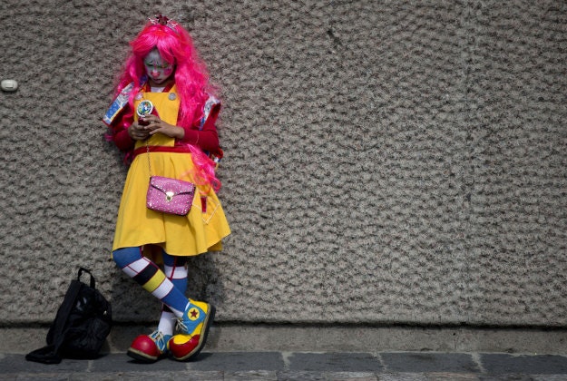 A clown checks her phone as she waits outside the Basilica of Our Lady of Guadalupe, in Mexico City, Monday, Dec. 14, 2015. Hundreds of clowns belonging to various clown associations made their annual pilgrimage to the Basilica on Monday to pay their respects to the Virgin of Guadalupe, Mexico's patron saint. 