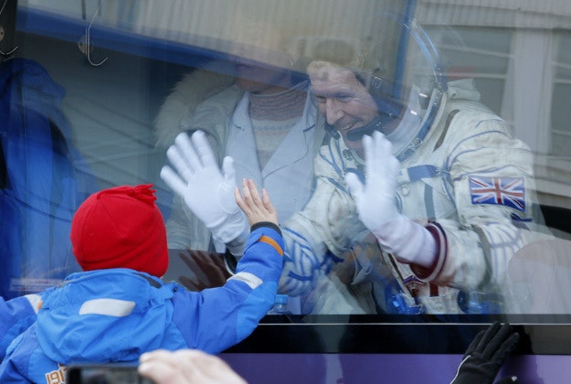 British astronaut Tim Peake, a member of the main crew of the expedition to the International Space Station (ISS), waves to his children from a bus prior to the launch of Soyuz TMA-19M space ship at the Russian leased Baikonur cosmodrome, Kazakhstan, Tuesday, Dec. 15, 2015. 