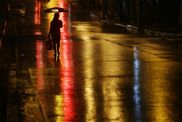 A woman walks during rainfall caused by Typhoon Melor in Quezon city, north of Manila, Philippines on Tuesday, Dec. 15, 2015. Typhoon Melor weakened Tuesday as it crossed over the central Philippines, leaving one man dead and wide areas without power. 