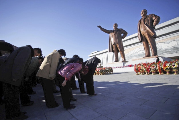 North Koreans bow on Mansu Hill, where bronze statues of late leaders Kim Jong Il and his father, Kim Il Sung, stand Thursday, Dec. 17, 2015, in Pyongyang, North Korea. Thousands visited the site to mark the fourth anniversary of Kim Jong Il's death. 