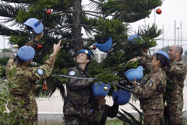 Italian U.N. peacekeepers decorate a Christmas tree with helmets at their base in the southern village of Chamaa, Lebanon, Thursday, Dec. 17, 2015. 