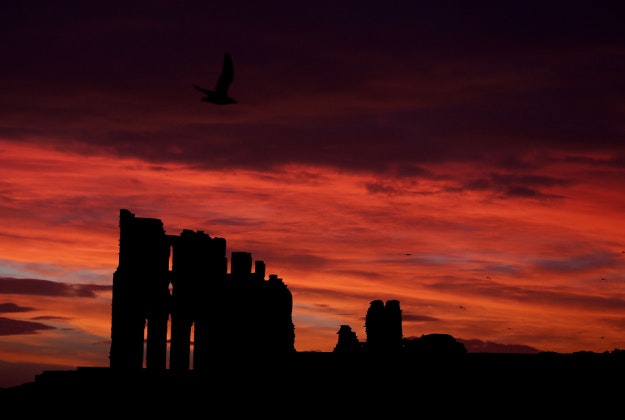 A fire glow sky at sunrise over Tynemouth Priory on the north east coast as parts of Britain continue to enjoy unseasonably warm weather.