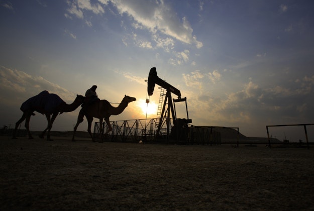 A man rides a camel through the desert oil field and winter camping area of Sakhir, Bahrain, Sunday, Dec. 20, 2015. Many Bahrainis head out to the desert during their free time in the winter months, enjoying picnics and socializing. 