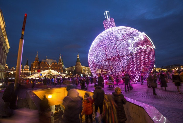 People walk at Manezhnaya Square illuminated to celebrate the upcoming Christmas and New Year next to a subway near Red Square in Moscow, Russia, Sunday, Dec. 20, 2015