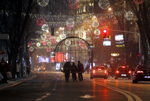 Workers carry a giant Christmas decoration through a street decorated for Christmas and New Year holidays, in downtown Skopje, Macedonia, on Monday, Dec. 21, 2015. 