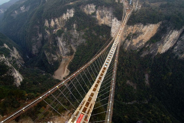 A partially-completed 430-meter (1,410-foot) bridge stretches about 300 meters (984 feet) above a valley in a scenic zone in Zhangjiajie in southern China's Hunan province Thursday, Dec. 3, 2015. According to Chinese media, the bridge will be the world's longest and highest glass-bottomed bridge when it is finished in 2016. 