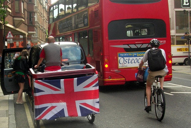 A rickshaw amongst London traffic.