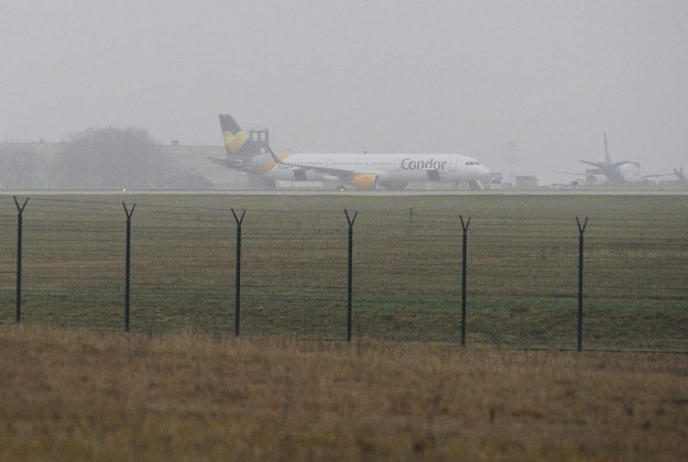 passenger plane of German Condor Airlines stands on the tarmac after it made an emergency landing because of a bomb threat at Liszt Ferenc International Airport in Budapest, Hungary, Monday, Dec. 7, 2015.
