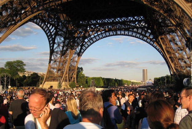 A crowd in Paris under the Eiffel Tower.