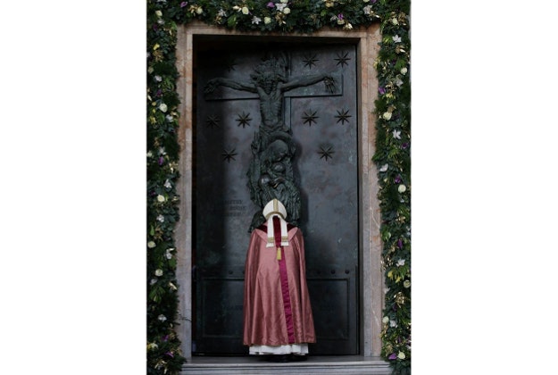 Pope Francis pushes to open the Holy Door of St. John in Lateran Basilica in Rome, Sunday, Dec. 13, 2015. 