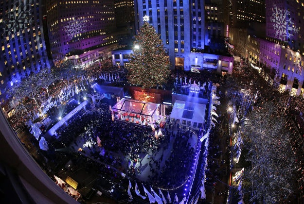 People watch as the Rockefeller Center Christmas tree is lit during a ceremony on Wednesday, Dec. 2, 2015, in New York. The Norway Spruce tree stands at about 78 feet tall and is lit with over 40,000 multi-colored LED lights.