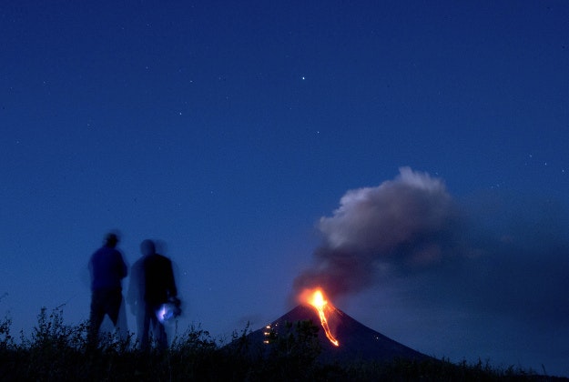 Nicaraguan Institute of Territorial Studies' employees watch from a distance the Momotombo volcano's eruption and lava flow, in the rural community of Papalonal, in Leon, Nicaragua, Wednesday, Dec, 2, 2015. Quiet for many years, the volcano emitted some glowing rock on Wednesday, after gas and ash emissions began Tuesday. In 1610, the city of Leon was destroyed during an eruption of the Momotombo and was relocated west, where it is currently located. 