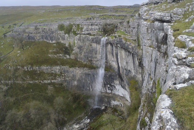 Water falls over the cliffs at Malham Cove