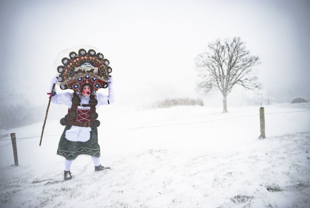 A traditional, masked so-called Silvesterchlaus is on his way in Waldstatt, Switzerland, Wednesday, Jan.13, 2016, to offer the best wishes for the New Year (following the Julian calendar) to the farmers in this region. After their performance of singing and dancing the Silvesterchlaeuse receive hot drinks. 