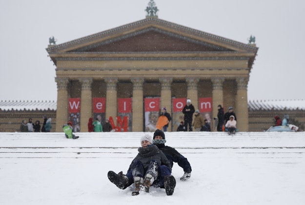 A couple sleds down the steps of the Philadelphia Museum of Art during a snowstorm, Saturday, Jan. 23, 2016, in Philadelphia. 