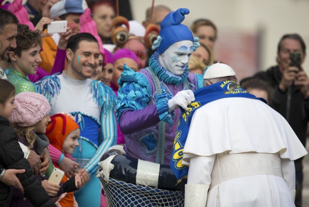 Circus artists who performed for Pope Francis during his weekly general audience give him a scarf of their circus, in St. Peter's Square, at the Vatican, Wednesday, Jan. 27, 2016