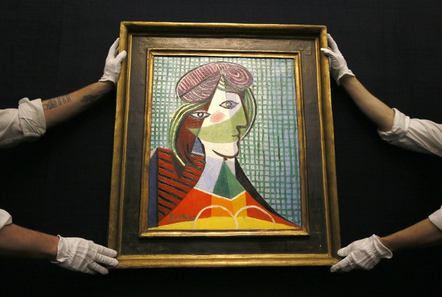 Sotheby's employees adjust a painting by Pablo Picasso called 'Tete de Femme' at the auction rooms in London, Thursday, Jan. 28, 2016. The painting is estimated at 16-20 million pounds (US$23-29 million) when it goes up for auction in London on Feb. 3. in the Impressionist and Modern Art Evening Sale. 