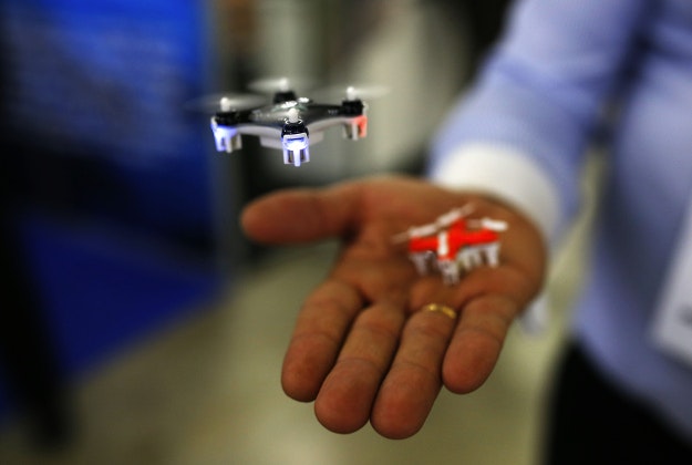 A man controls a mini drone during the Global Robot Expo fair in Madrid, Thursday, Jan. 28, 2016. During the four days fair experts from the public and private sector show their technology achievements in the robotic sector. 