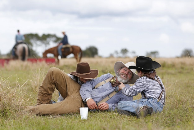 In this Tuesday, Jan. 26, 2016 photo, Richard Claybrooke, center, of Parrish, Fla., sits with his sons Brady, left, 7, and Logan, 10, after stopping for lunch during the Great Florida Cattle Drive 2016, in Kenansville, Fla. The once-a-decade event was organized to draw attention to Florida's deep cowboy history. 