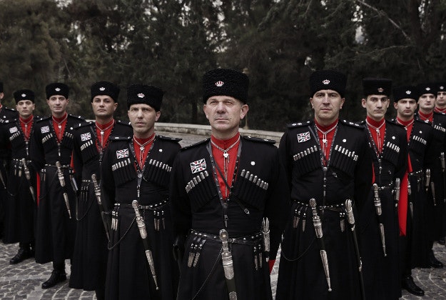 In this Monday, Jan. 11, 2016 photo, Circassian guards pose for a photograph outside Basman Palace, in Amman, Jordan. Circassian guards, who have served Jordan's kings since the founding of the monarchy, still adhere to their ancient traditions, such as donning an incongruous cold weather uniform of black wool hats, red capes and leather boots in this desert climate. 