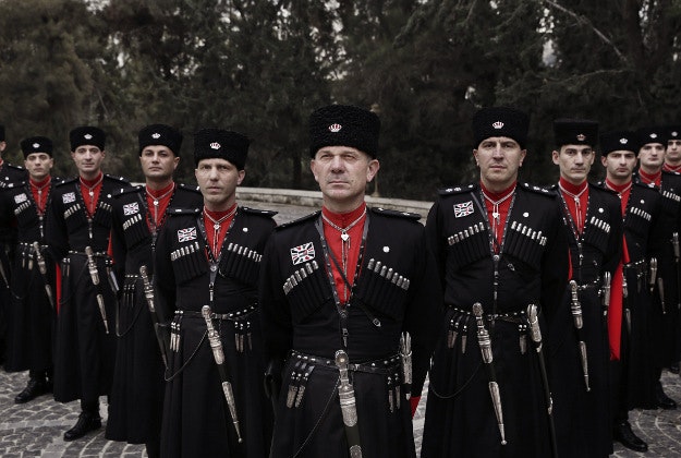 In this Monday, Jan. 11, 2016 photo, Circassian guards pose for a photograph outside Basman Palace, in Amman, Jordan. Circassian guards, who have served Jordan's kings since the founding of the monarchy, still adhere to their ancient traditions, such as donning an incongruous cold weather uniform of black wool hats, red capes and leather boots in this desert climate.