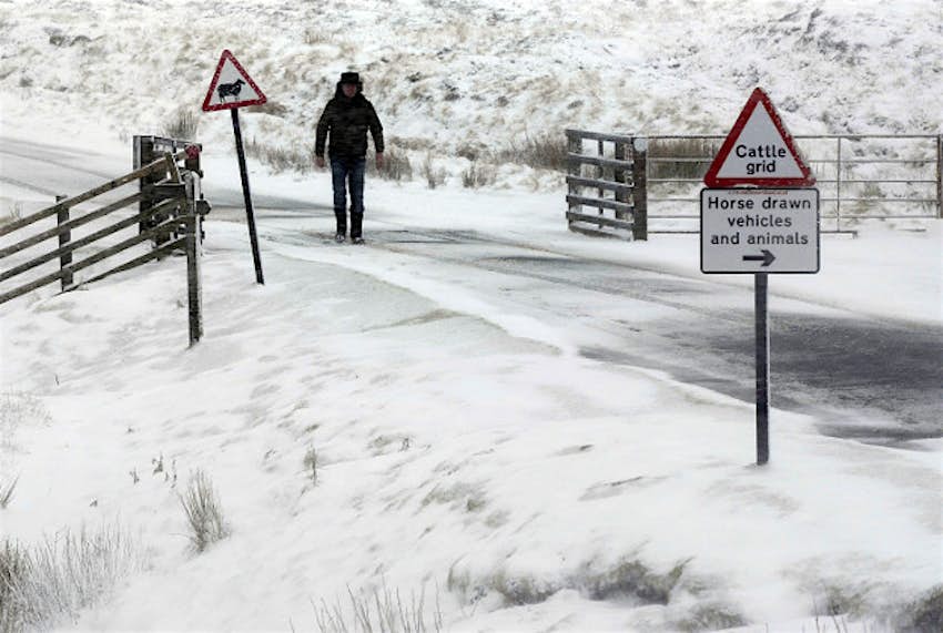 Travel News - england snow 1 A person walks in the snow in Swaledale, North Yorkshire, as winter weather hits the Pennines.