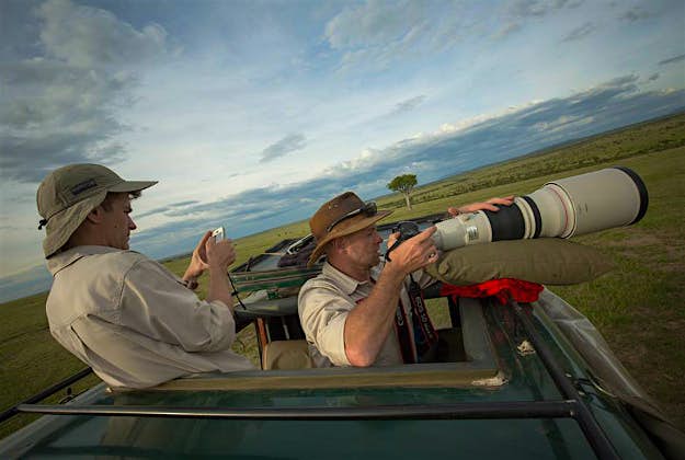Travel News - makeitkenya3 In a photpgraph taken by Make It Kenya 07 January 2016, Andre Van Kets (left) and Carel Verhoef, creators of the website HerdTracker, an online resource which tracks and documents east Africa's great wildebeest migration, prepare to stream a live broadcast on the Periscope application.