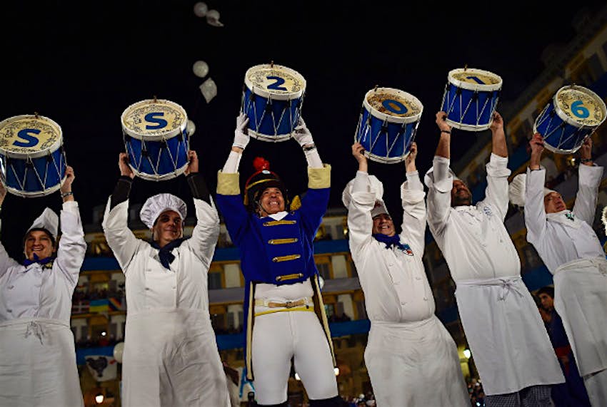 Travel News - spain 3 Tamborilleros wearing their uniforms raise their drums during opening midnight cermemony