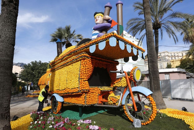 A worker sets up a giant sculpture decorated with oranges and lemons during the 83th Lemon festival in Menton, southeastern France, Thursday. The festival will tribute Italian cinema "Cinecitta" from February 13th to March 2nd. 