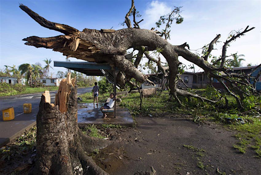 Travel News - 11254571-1 Two boys are under a bus shelter that is supporting a fallen tree in the village of Talecake, Fiji, Wednesday, Feb. 24, 2016, after cyclone Winston ripped through the island nation. The cyclone tore through Fiji over the weekend with winds that reached 177 miles (285 kilometers) per hour, making it the strongest storm in Fiji's recorded history.