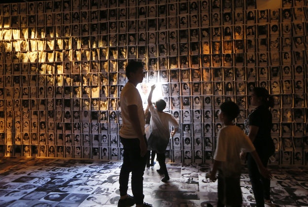 Children walk through walls of portraits of victims under the 20-year-rule of the late strongman Ferdinand Marcos during the opening of the "experiential museum" to coincide with the 30th commemoration of the "People Power Revolution" that ousted the Marcoses from power and helped install Corazon "Cory" Aquino to the presidency Wednesday, Feb. 24, 2016 at suburban Quezon city northeast of Manila, Philippines. The Holocaust-type museum was conceived to remind the young generation of the abuses and human rights violations perpetrated under years of Martial Rule in the country.(