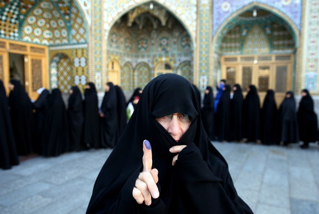 An Iranian woman displays her ink-stained finger after voting in the parliamentary and Experts Assembly elections at a polling station in Qom, 125 kilometers (78 miles) south of the capital Tehran, Iran, Friday, Feb. 26, 2016. Polls opened Friday in Iran's parliamentary elections, the country's first since its landmark nuclear deal with world powers last summer. 