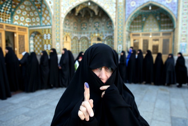 An Iranian woman displays her ink-stained finger after voting in the parliamentary and Experts Assembly elections at a polling station in Qom, 125 kilometers (78 miles) south of the capital Tehran, Iran, Friday, Feb. 26, 2016. Polls opened Friday in Iran's parliamentary elections, the country's first since its landmark nuclear deal with world powers last summer.