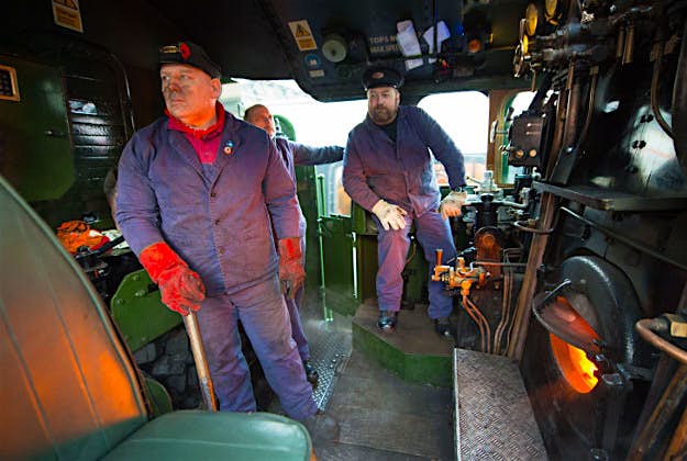 Travel News - flying scotsman london 2 Crew members in the cab of the Flying Scotsman before its inaugural run from Kings Cross station, London, to York after a decade long, £4.2 million refit.