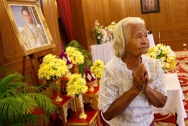 Travel News - pic 7 Yuphin Karnjanasriratip prays in front of a portrait of Thai King Bhumibol Adulyadej in Thailand