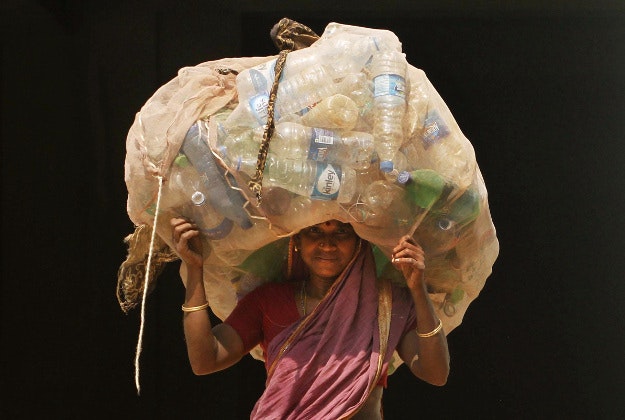 An Indian woman carries a sack of used plastic bottles to be sold at a recycled plant on the International Womans Day in the eastern Indian city of Bhubaneswar, India, Tuesday, March 8, 2016.