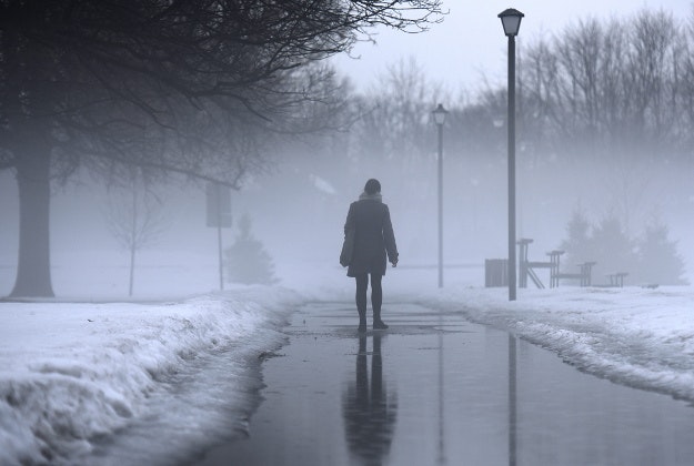 A woman walks in Brewer Park as heavy fog rises on Wednesday, March 9, 2016 in Ottawa. 