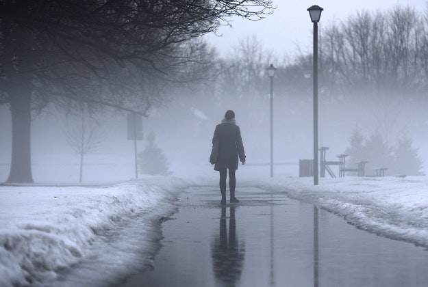 A woman walks in Brewer Park as heavy fog rises on Wednesday, March 9, 2016 in Ottawa.