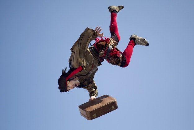 An acrobat jumps from the top of a school building during a performance for foreign migrant workers children to celebrate the Purim festival in Tel Aviv, Israel, Tuesday, March 22, 2016. The Jewish holiday of Purim commemorates the Jews' salvation from genocide in ancient Persia, as recounted in the Book of Esther, which is read in synagogues. Other customs include: sending food parcels and giving charity; dressing up in masks and costumes; eating a festive meal; and public celebrations. 