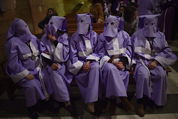 Travel News - 11535082-1 Masked penitents rest inside the church after taking part in the procession of the "Ensogado", during Holy Week in Sietamo, northern Spain, Thursday, March 24, 2016. Hundreds of processions take place throughout Spain during the Easter Holy Week.