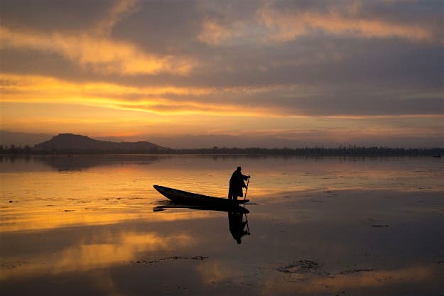 Travel News - INDIA Kashmir 154815 A Kashmiri fisherman rows his Shikara, or traditional boat, during sunset at the Dal Lake in Srinagar, Indian controlled Kashmir, Tuesday, March 29, 2016.Nestled in the Himalayan mountains and known for its beautiful lakes and saucer-shaped valleys, the Indian portion of Kashmir, is also one of the most militarized places on earth.