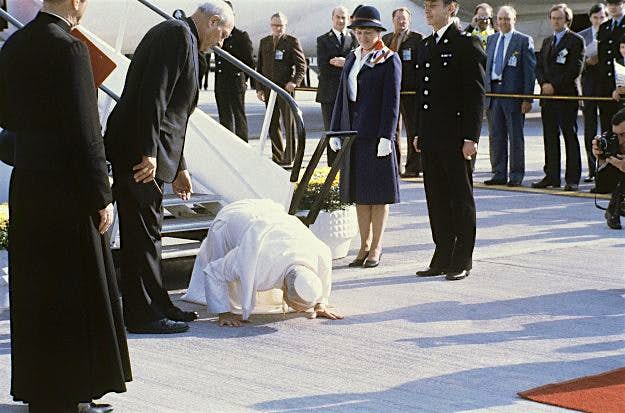 Travel News - England Pope John Paul II Visit UK Pope John Paul II kisses the ground as he arrives at Gatwick Airport for a six day visit to Great Britain on May 28th, 1982.